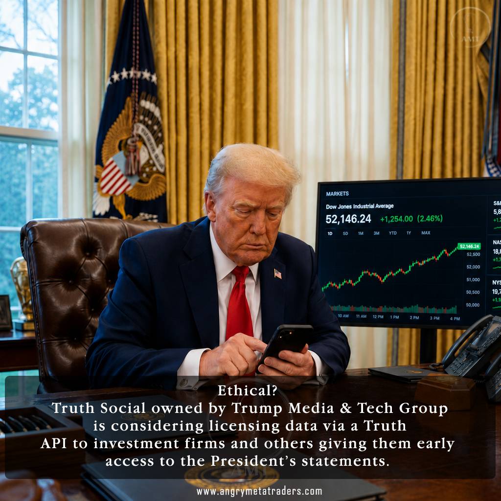Donald Trump sits behind the Resolute Desk in the Oval Office, posting on his smartphone beside a trading monitor displaying rising Wall Street market charts.